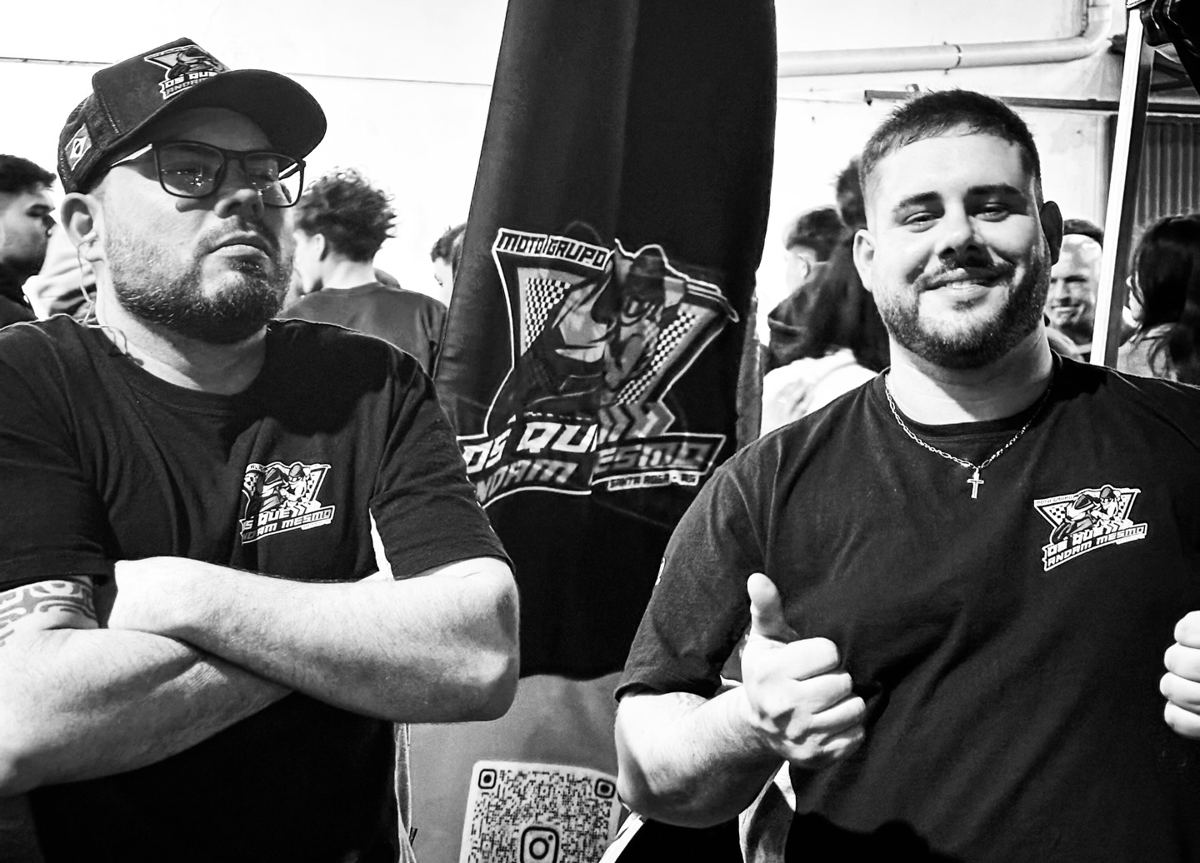 Dois membros sorrindo com as camisetas do grupo