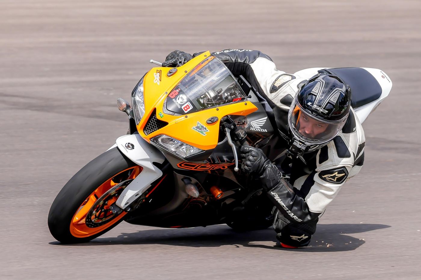 Moto amarela com joelho no chão