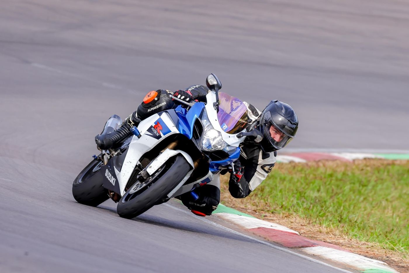 Moto azul e branca contornando a curva